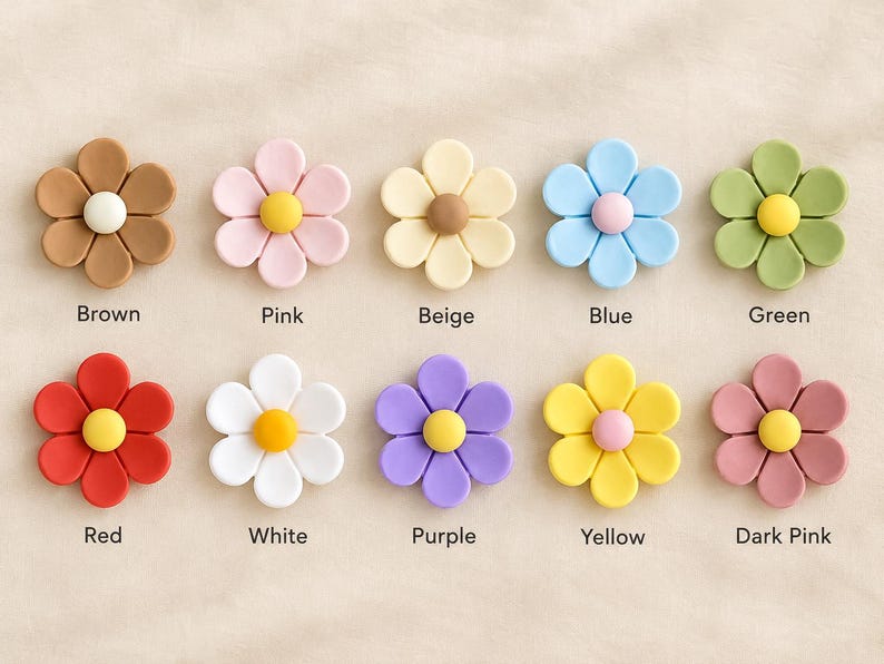 May include: Ten flower-shaped buttons arranged in two rows. Each button has five petals and a central circular accent. Colors include brown, pink, beige, blue, green, red, white, purple, yellow, and dark pink, with labels below each.