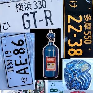 Peut inclure: Une collection d'objets décoratifs sur le thème de l'automobile, comprenant des plaques d'immatriculation, une illustration de moteur de voiture, un étrier de frein, un autocollant avec un geste de la main et un désodorisant de voiture en forme de bouteille de protoxyde d'azote. Les plaques d'immatriculation présentent du texte et des chiffres japonais. Le désodorisant est bleu avec le mot "NOS" imprimé dessus.