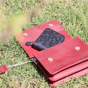 May include: A red leather wallet with a black leather wallet inside. The red wallet has a gold snap closure and the text "V. Lovely" embossed on the front.