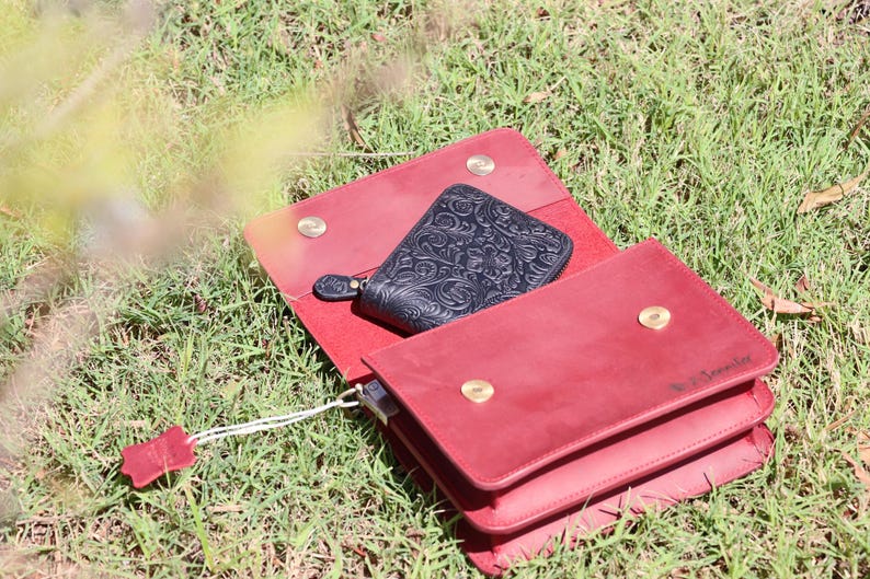 May include: A red leather wallet with a black leather wallet inside. The red wallet has a gold snap closure and the text "V. Lovely" embossed on the front.