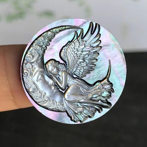 Zwarte parelmoer cameebedel meisjes: sikkelvormige cabochon met gevleugelde dweil, 25 mm