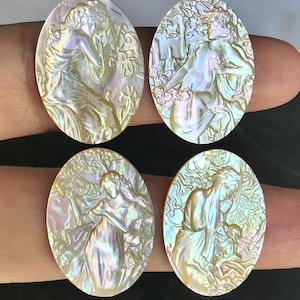 May include: Four oval mother-of-pearl cameos. Each cameo depicts a classical female figure in relief, surrounded by floral and natural motifs. The iridescent surface shimmers with gold, pink, and green hues.
