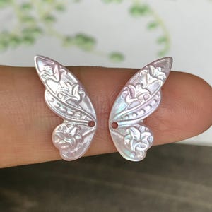 1 paio di piccole ali di farfalla intagliate in madreperla rosa, con motivo a giglio
