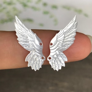 Pequeñas alas talladas de nácar blanco con plumas, 1 par.