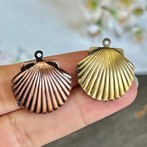 May include: Two metal seashell charms, one gold and one copper, with a loop at the top for attaching to jewelry or crafts.