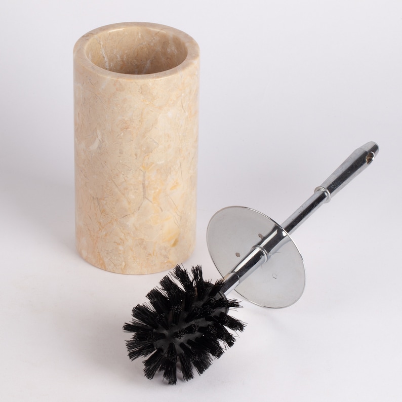 May include: A beige marble toilet brush holder with a chrome toilet brush with black bristles.