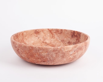 Puede incluir: Un tazón grande, redondo, de color marrón claro hecho de piedra natural con un patrón de mármol. El tazón está vacío y tiene una superficie lisa ligeramente texturizada.