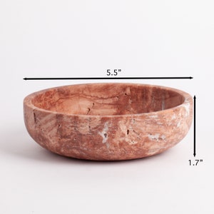 May include: A round, brown and white marble bowl with a diameter of 5.5 inches and a height of 1.7 inches.
