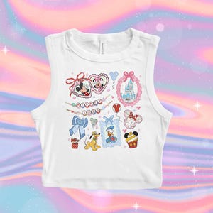 May include: White sleeveless crop top with a colorful print of various Disney characters, including Mickey Mouse, Minnie Mouse, Donald Duck, Goofy, and the Cinderella castle. The print also includes hearts, bows, and the text "Mickey 2023".