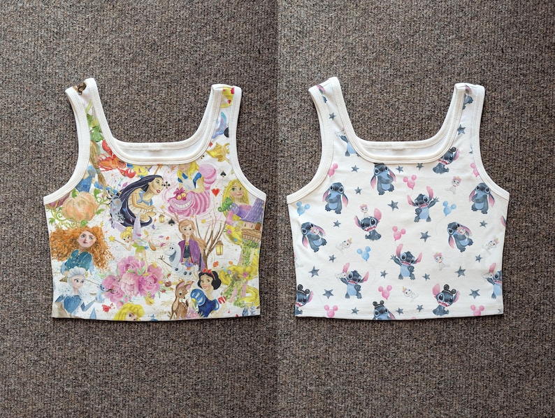 May include: Two white crop tops with a square neckline. One top features a colorful collage of Disney princesses and characters. The other top has a pattern of the character Stitch, with pink and blue accents, and stars.