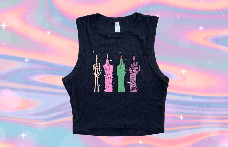 May include: Black sleeveless crop top featuring a graphic of four stylized hands giving the middle finger. The hands are depicted as a skeleton, pink fur, green skin, and wrapped in bandages. The nails are painted red and black.