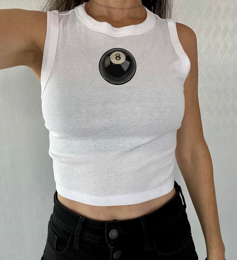 May include: White sleeveless crop top with a black and white 8-ball graphic on the front.