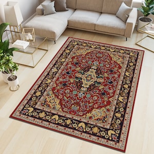 Può includere: Un tappeto rettangolare con un design tradizionale e ornato. Il tappeto presenta un campo centrale rosso intenso con un motivo floreale e geometrico dettagliato nei toni dell'oro, del blu e del verde. Un bordo blu scuro incornicia il design.