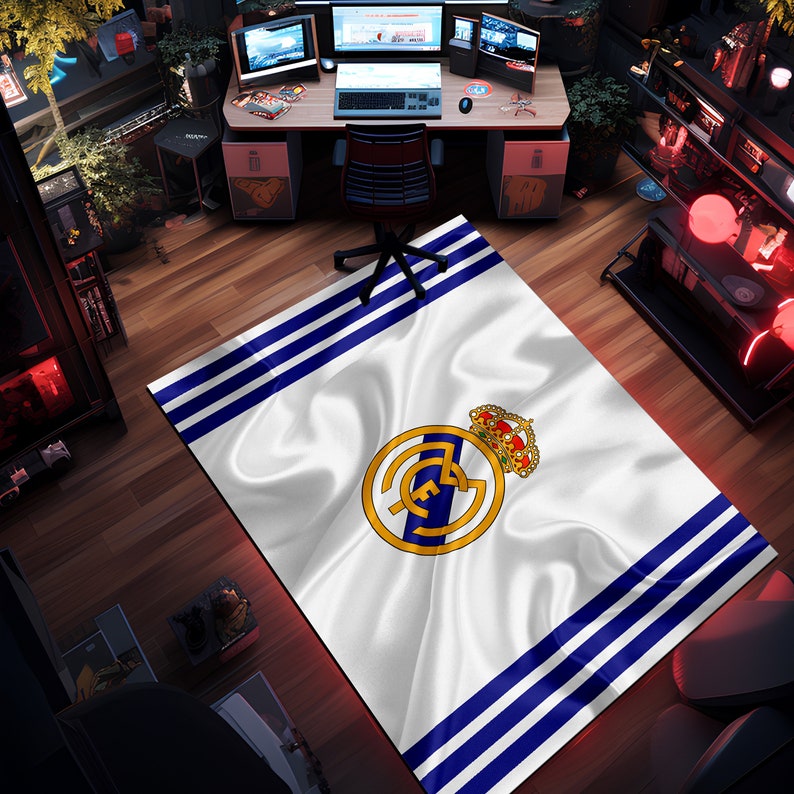 Puede incluir: Alfombra blanca y azul con un logotipo de equipo de f&uacute;tbol en el centro. El logotipo es un c&iacute;rculo blanco con una estrella azul y una corona dorada en la parte superior. La alfombra tiene un fondo blanco con rayas azules.