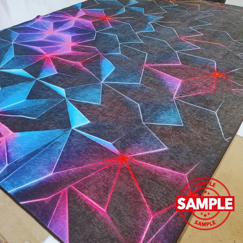 Puede incluir: Una alfombra geom&eacute;trica negra y gris con acentos azules, rosas y rojos. La alfombra tiene un sello "SAMPLE" en la esquina inferior derecha.