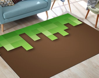 May include: A brown and green area rug with a pixelated design of grass blocks on a brown dirt background. The rug is laid out on a wooden floor with a blue sofa and a small table in the background.