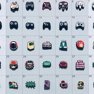 May include: A set of 35 colorful shoe charms featuring various gaming-themed designs, including controllers, characters, and phrases like "Game On!" and "Gamer".