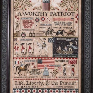 May include: Framed cross-stitch sampler depicting historical events. The artwork features text and illustrations of the American Revolution, including dates, figures, and flags. The color palette includes beige, red, blue, and black.