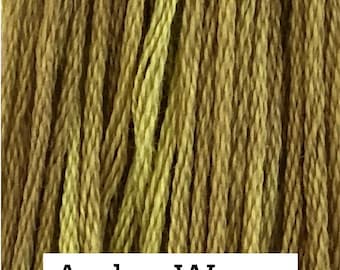 May include: A collection of vertical, multi-ply embroidery threads in varying shades of golden yellow and olive green. A white rectangular label at the bottom displays the text Amber Waves in a black serif font, identifying the colorway.