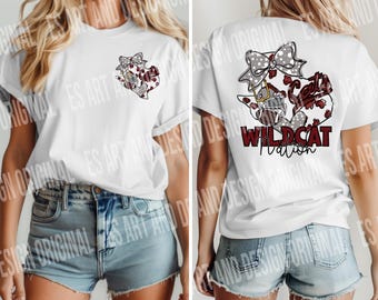 May include: White t-shirt with a red, white, and black graphic design of a football helmet with a bow and the text "Wildcat Nation".