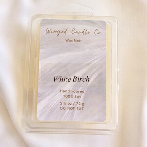 May include: A white wax melt in a clear plastic container with the label "Winged Candle Co. Wax Melt" and "White Birch" with the details "Hand Poured 100% Soy 2.5 oz / 72 g DO NOT EAT".