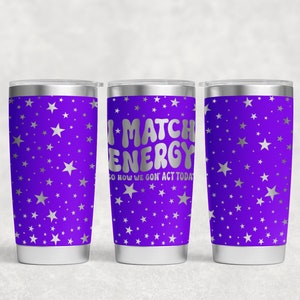 May include: Three stainless steel tumblers with a purple background and silver stars. The middle tumbler has the text "I MATCH ENERGY SO HOW WE GON' ACT TODAY" in silver lettering.
