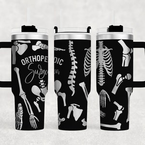 May include: A black stainless steel tumbler with a white design of various bones and the text "Orthopedic Surgeon". The tumbler has a black handle and a lid with a straw.
