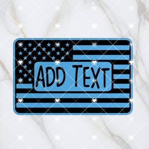May include: Rectangular license plate design with a blue and black American flag theme. The top left corner features a field of black stars on a blue background. The rest of the plate has black and blue stripes. The text "ADD TEXT" is in a blue rectangle.