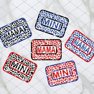 May include: Six different iron-on patches with a leopard print design. The patches feature the words "Mama" and "Mini" in white text with a red, blue, or black outline.