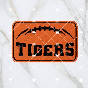 Könnte beinhalten: Orangefarbener und schwarzer Fußmatte mit Fußball-Motiv und dem Wort "TIGERS" in schwarzen Buchstaben.