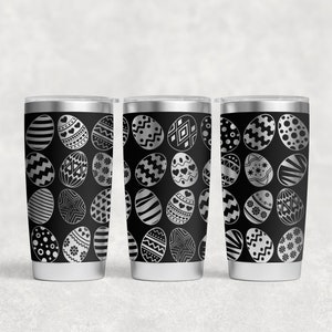 May include: Three stainless steel tumblers with black and white patterned Easter egg designs. The tumblers are insulated and have a lid.