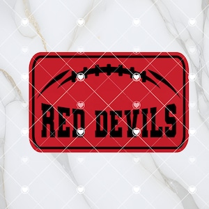 May include: Red Devils text with a black football graphic on a red background. The text is in a black rectangle.