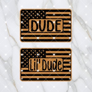 Pode incluir: Dois sinais de madeira com um design de bandeira americana. O sinal superior diz "DUDE" e o sinal inferior diz "Lil' Dude".