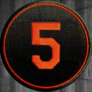 May include: A black and orange embroidered patch with the number 5 in the center.
