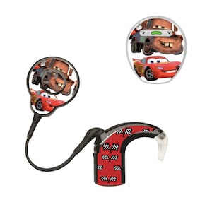 Puede incluir: Un audífono negro y rojo con un auricular transparente. El audífono presenta imágenes de los personajes de la película Cars, Mater y Rayo McQueen. El audífono tiene una sección roja con diseños de banderas a cuadros en blanco y negro.