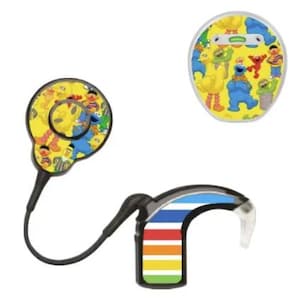 May include: Three hearing aid devices with colourful designs. One has a yellow background with Sesame Street characters. Another has a rainbow stripe design. The third is a round device with Sesame Street characters.