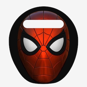 以下が含まれることがあります： 白いレンズとクモの巣模様の赤と黒のスパイダーマンマスク。マスクは、上部に白い長方形の開口部がある黒い円形の背景に配置されています。