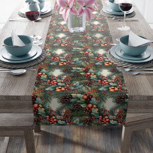 Peut inclure: Une nappe décorative avec un motif répété de pommes de pin, de baies rouges et de feuillage vert. La nappe est placée sur une table en bois dressée pour un repas, avec des assiettes, des bols et des verres à vin. La table est décorée de fleurs roses.