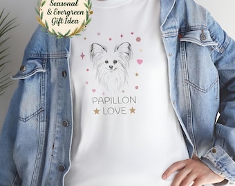 Puede incluir: Camiseta blanca con una ilustración de perro Papillon y el texto "PAPILLON LOVE". El diseño incluye corazones y estrellas rosas. Una idea de regalo de temporada se muestra en la esquina superior izquierda.