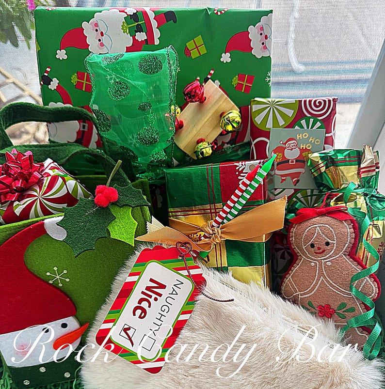 May include: A collection of wrapped Christmas gifts in various sizes and patterns, including Santa Claus and holiday-themed designs. A tag reads "Nice" and "Naughty". Decorative elements include a gingerbread person, bows, and bells.