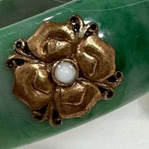 Klobiger grüner Armreif mit floralen Goldakzenten