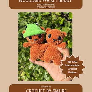 May include: Two small, orange, plush crochet figures with black safety eyes and embroidered mouths. One figure wears a bright green, textured bucket hat. The text reads: WOODLAND POCKET BUDDY, W/ HAT MODIFICATIONS, PDF CROCHET PATTERN, No Sew, Intermediate Crochet Pattern, DESIGNED BY CROCHET BY SMURF.