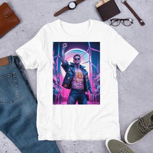May include: White t-shirt with a graphic print of a man in a leather jacket with a Bitcoin symbol on his chest. The man is standing in a futuristic city with neon lights and wind turbines.