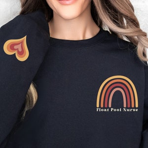May include: Black sweatshirt with a rainbow graphic and the text "Float Pool Nurse" on the front. The left sleeve has a heart graphic.