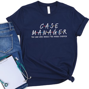 May include: Navy blue t-shirt with the text "CASE MANAGER" in white, with colorful heart accents. The phrase "THE ONE WHO MAKES THE MAGIC HAPPEN" is below. The shirt is paired with blue jeans, a clipboard, and a stethoscope.