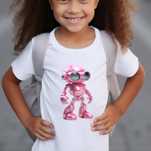 Pode incluir: Uma menina jovem vestindo uma camiseta branca com um robô rosa estampado. O robô tem olhos grandes e redondos e um acabamento metálico.