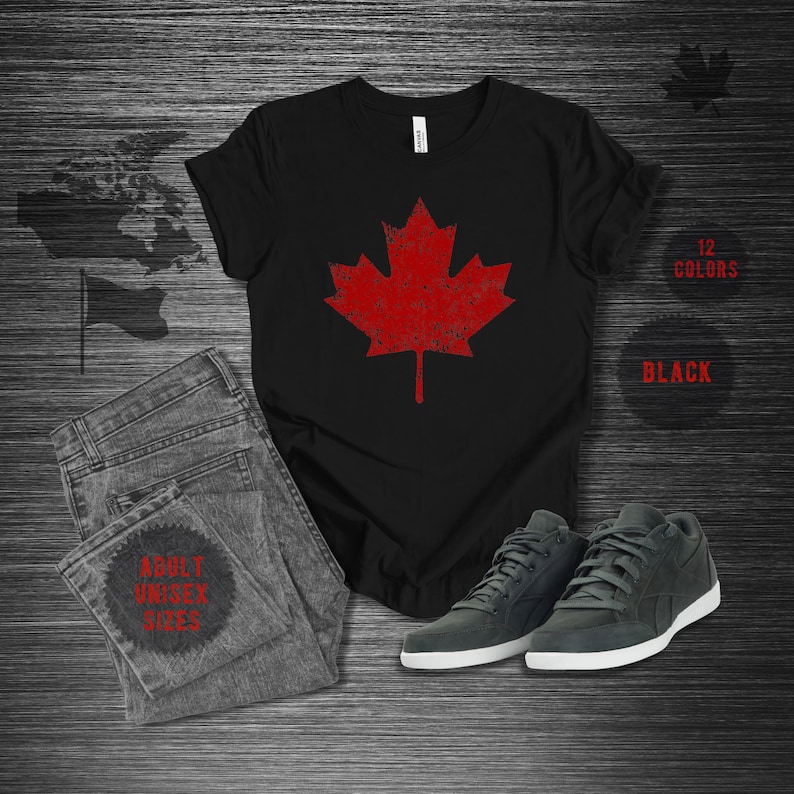K&ouml;nnte beinhalten: Schwarzes T-Shirt mit einem roten Ahornblatt-Design im Used-Look, kombiniert mit grauen Jeans und Turnschuhen. Das Bild enth&auml;lt auch den Text "12 COLORS", "BLACK" und "ADULT UNISEX SIZES".