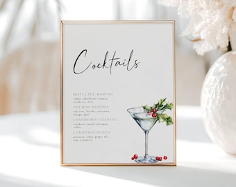 May include: A framed sign with the word "Cocktails" in elegant script. Below, a list of cocktail recipes includes a Mistletoe Martini and Holiday Sangria. A watercolor illustration of a martini glass with holly and berries decorates the sign.