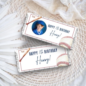 May include: Two baseball-themed birthday party favors. Each features a baseball, a bat, and the text "HAPPY 8th BIRTHDAY Henry!" One favor includes a photo of a child in a baseball uniform.