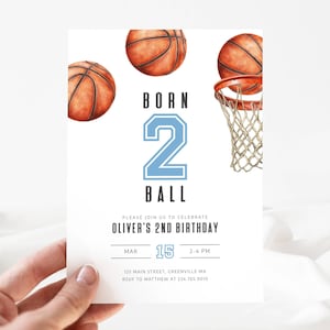 May include: A white invitation card with basketball-themed graphics. The text reads "BORN 2 BALL" with a large number 2 in light blue. The invitation is for Oliver's 2nd birthday, with the date March 15th and a time of 2-4 PM.